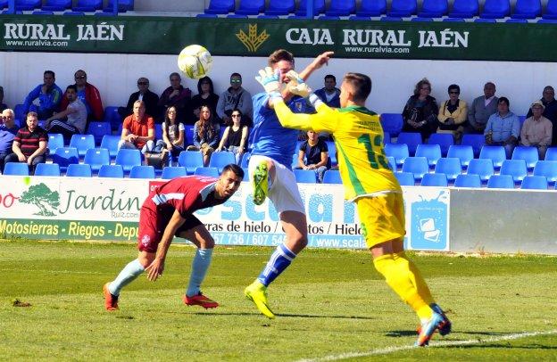 Pekes luchando con el portero rival por hacerse con un remate a portería en un partido en Linarejos.