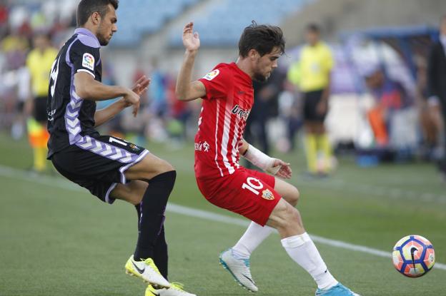 José Ángel Pozo intenta controlar el balón, acosado por Jordán, en el último duelo entre la UDA y el Real Valladolid. /CHEMA ARTERO