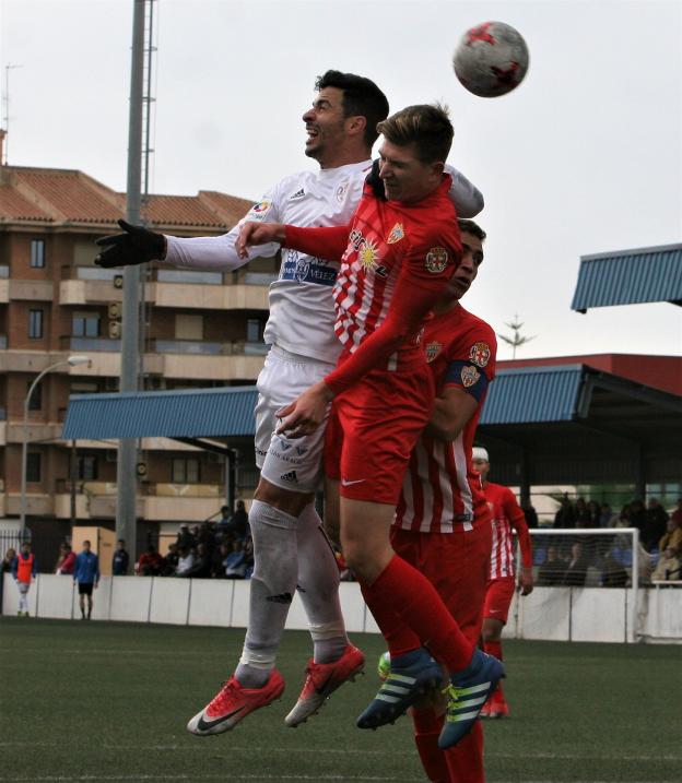 Urri (d) trata de ganar una disputa aérea en el partido celebrado ayer en Vélez./JESÚS HURTADO