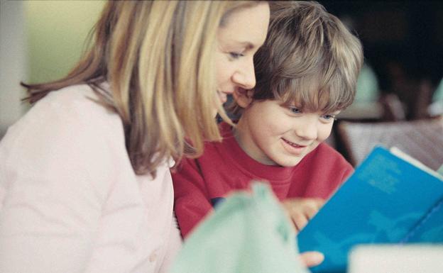 Una madre lee un libro con su hijo./Archivo