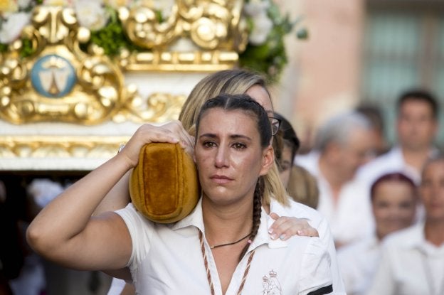 Una costalera contiene las lágrimas mientras lleva a la Virgen del Carmen en Motril. :: firma/