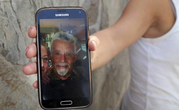 Un vecino muestra una de las últimas fotos realizadas al fallecido de 63 años, tras recibir esta mañana varios disparos en la calle Nueva de San Juan de la localidad de Güevéjar.