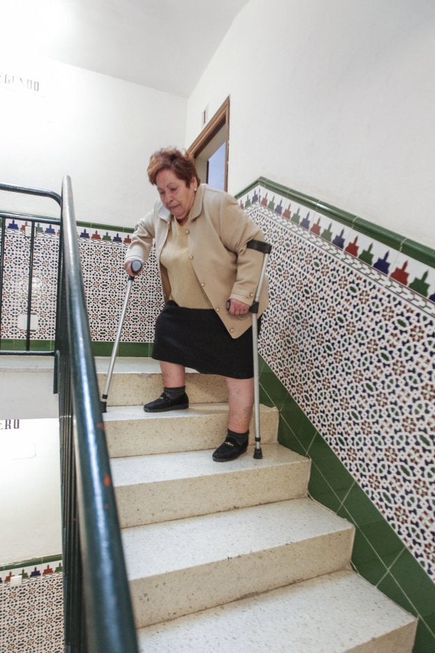 Una mujer baja por las escaleras de un bloque de viviendas.