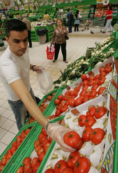 Un joven compra verduras en un supermercado.