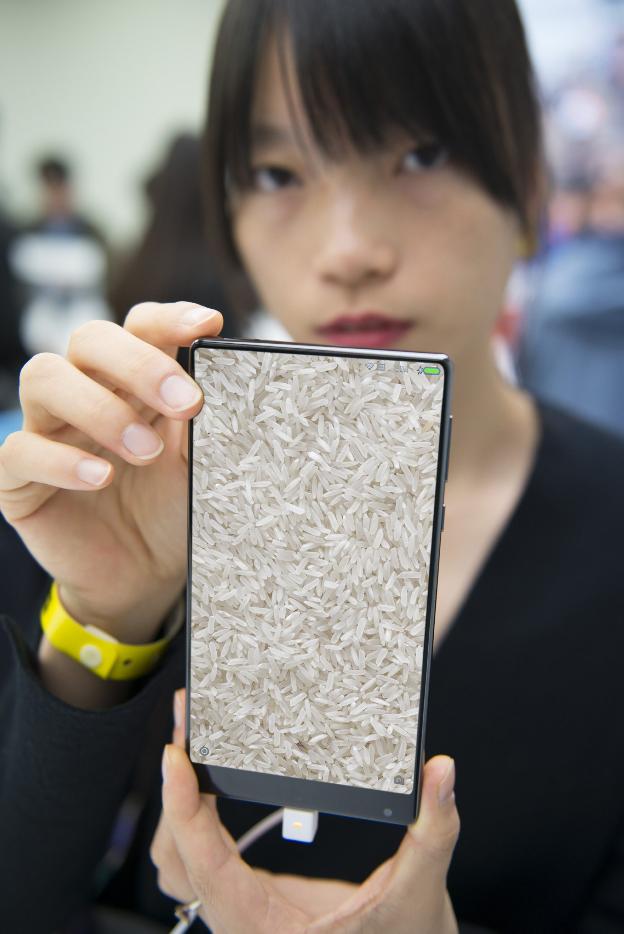 Al grano. Una joven muestra un terminal de Xiaomi, que en chino se traduce como arroz./