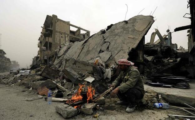 Un sirio, junto a una hoguera en la ciudad de Raqa./Afp