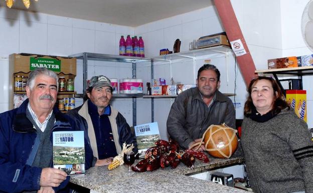El alcalde pedáneo del pueblo alpujarreño de Yátor, José Ortiz De Toro (a la izquierda), con un programa de fiestas en compañías de varios amigos de este lugar en un bar./
