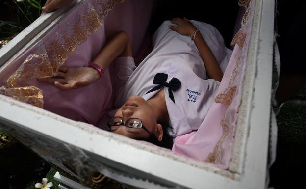 Una cliente prueba a tumbarse en un ataúd. /LILLIAN SUWANRUMPHA (AFP)