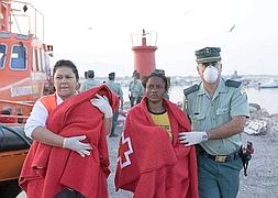 Una mujer y un bebé que iban en la patera rescata, a su llegada a Motril. /EFE/