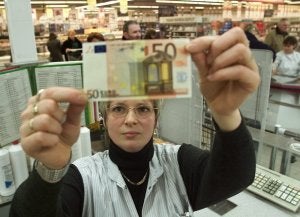 Una empleada de una gran superficie comprueba un billete de 50./IDEAL/