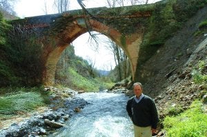 El concejal de Urbanismo de Válor, Natalio Garrido, ante el histórico puente del municipio. :: RAFAEL VÍLCHEZ/