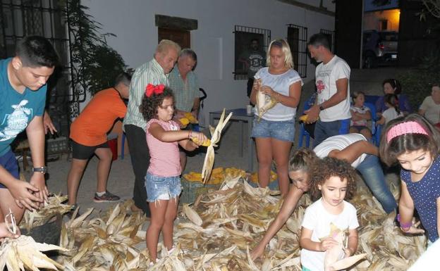 Varias generaciones se unen en La Alquería para desgranar el maíz