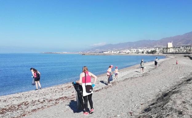 Un grupo de voluntarios limpia la playa de El Censo de Adra