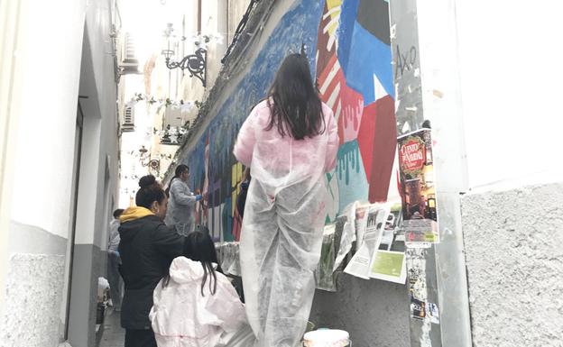 Jóvenes artistas decoran el callejón del Yoyo con una original postal navideña