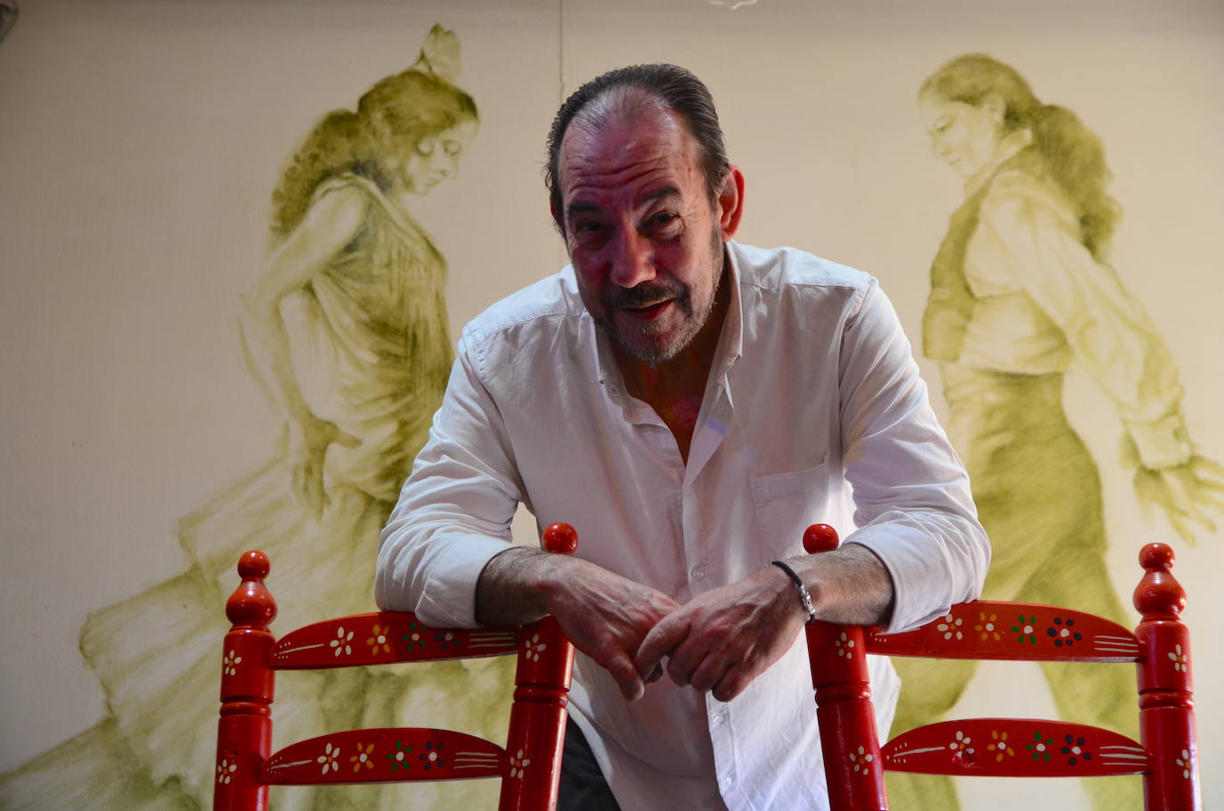 Miguel Baños, en el escenario de La Parra Flamenca, con pinturas de David 'Zaafra' detrás./DIEGO LUZ