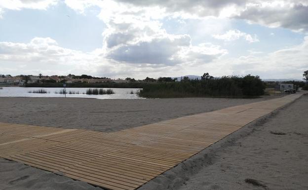 Una pasarela de madera une las orillas de la laguna de Puerto Rey