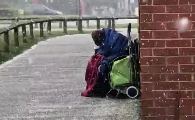 La foto de un anciano indigente hecho un ovillo bajo la nieve agita conciencias