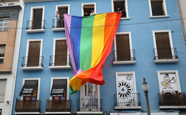 Una bandera arcoíris gigante en Reyes Católicos planta cara a los semáforos negros de Puerta Real