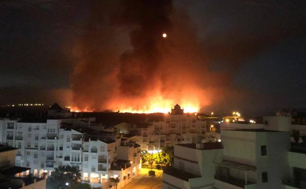 Los bomberos trabajan toda la noche para extinguir el fuego de Salobreña, que se reactivó por el viento