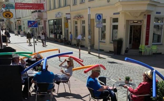 Una terraza utiliza churros de natación para mantener la distancia entre clientes