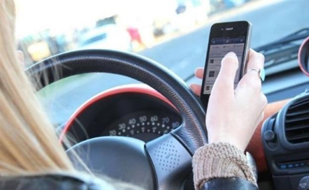 Aviso de la DGT sobre la multa de 200 euros por coger el móvil parado en un semáforo