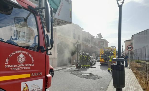 Bomberos sofocan un fuego en un coche dentro del garaje de una casa de Armilla