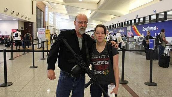 Recoge a su hija en el aeropuerto con un fusil colgado del brazo y desata la polémica