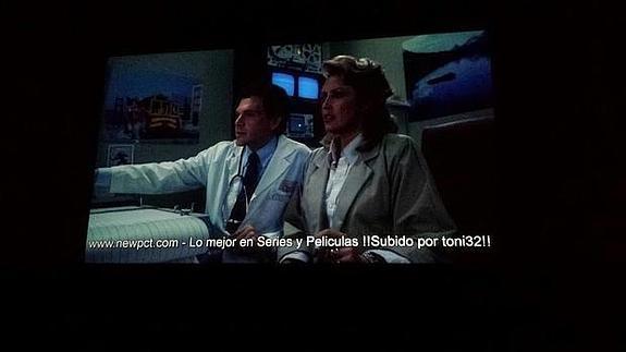 Un cine proyecta una película con la marca de agua de una página de descargas piratas