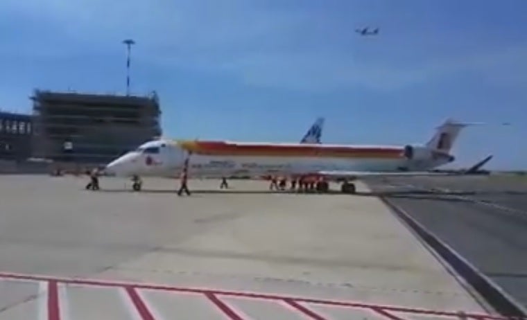 Empleados empujan a un avión de Iberia para que despegue hacia Vigo